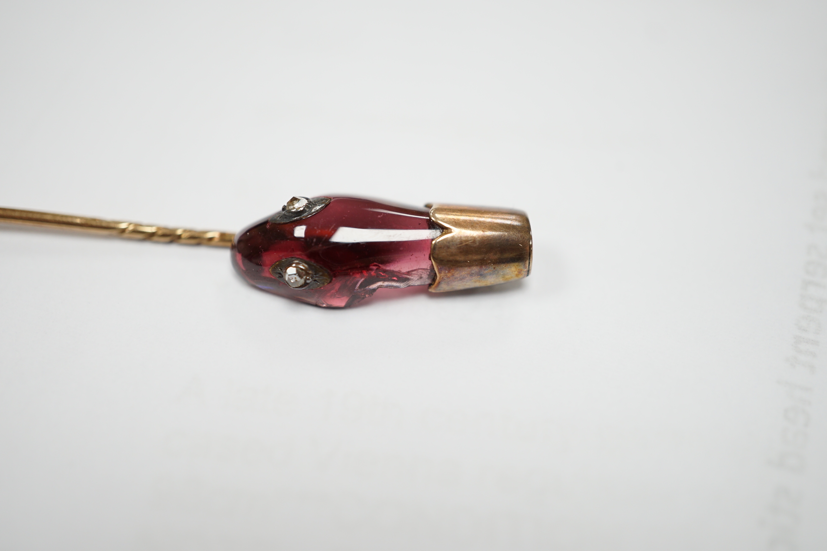 A late Victorian yellow metal, garnet and diamond set serpent head stick pin, 65mm, gross weight 2.9 grams (chip).